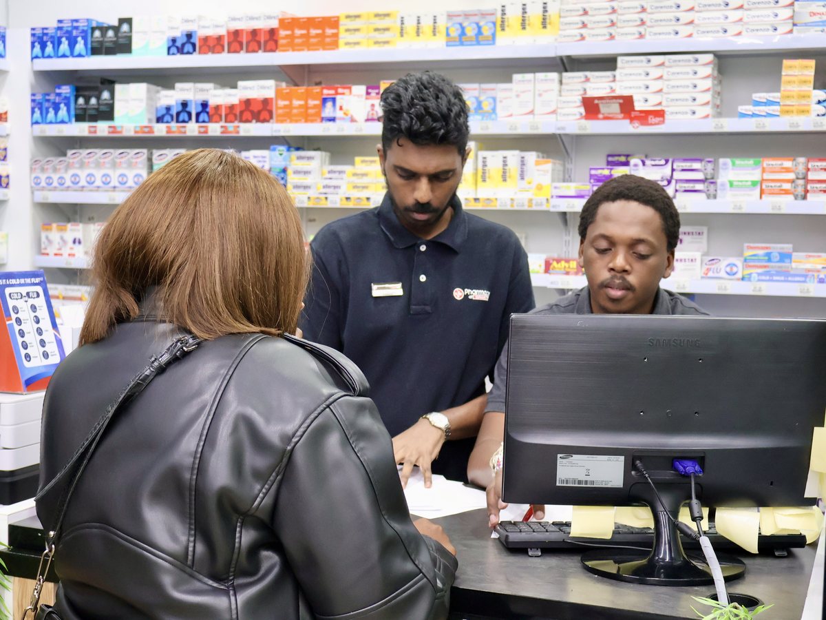 Two of the team serving a customer at the dispensary counter
